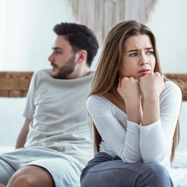 Mann und Frau auf dem Bett, weggedreht, Streit